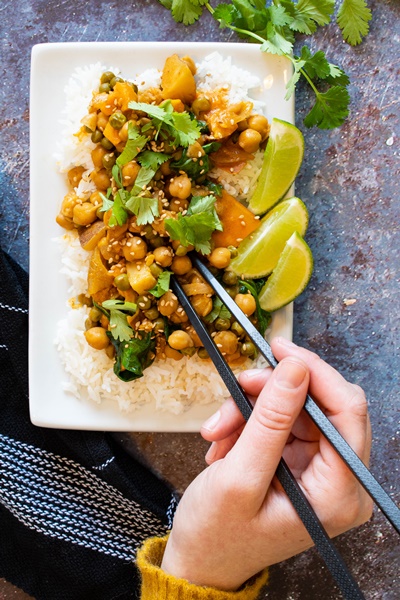 Curry végétarien de patates douces et pois chiches d’inspiration thaïlandaise avec main et limes